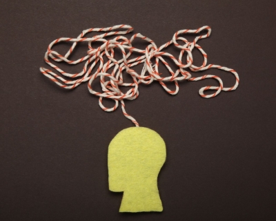 A yellow silhouette of a human head with a jumble of red and white string coming out of the stop