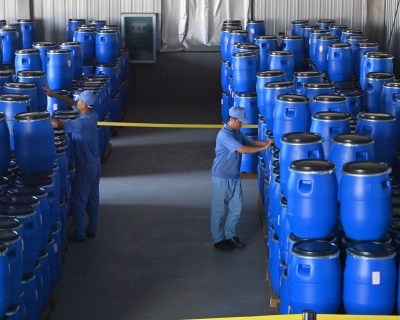 Employees transfer barrels of artemisinin at a pharmaceutical company in southern China on Aug. 27, 2024.