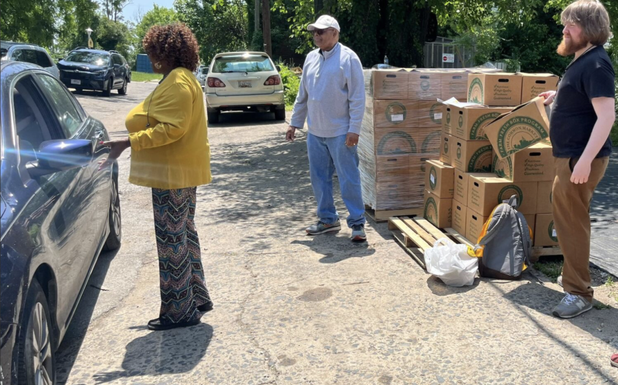 Ms. Pat and farmers distributing food boxes to cars. 